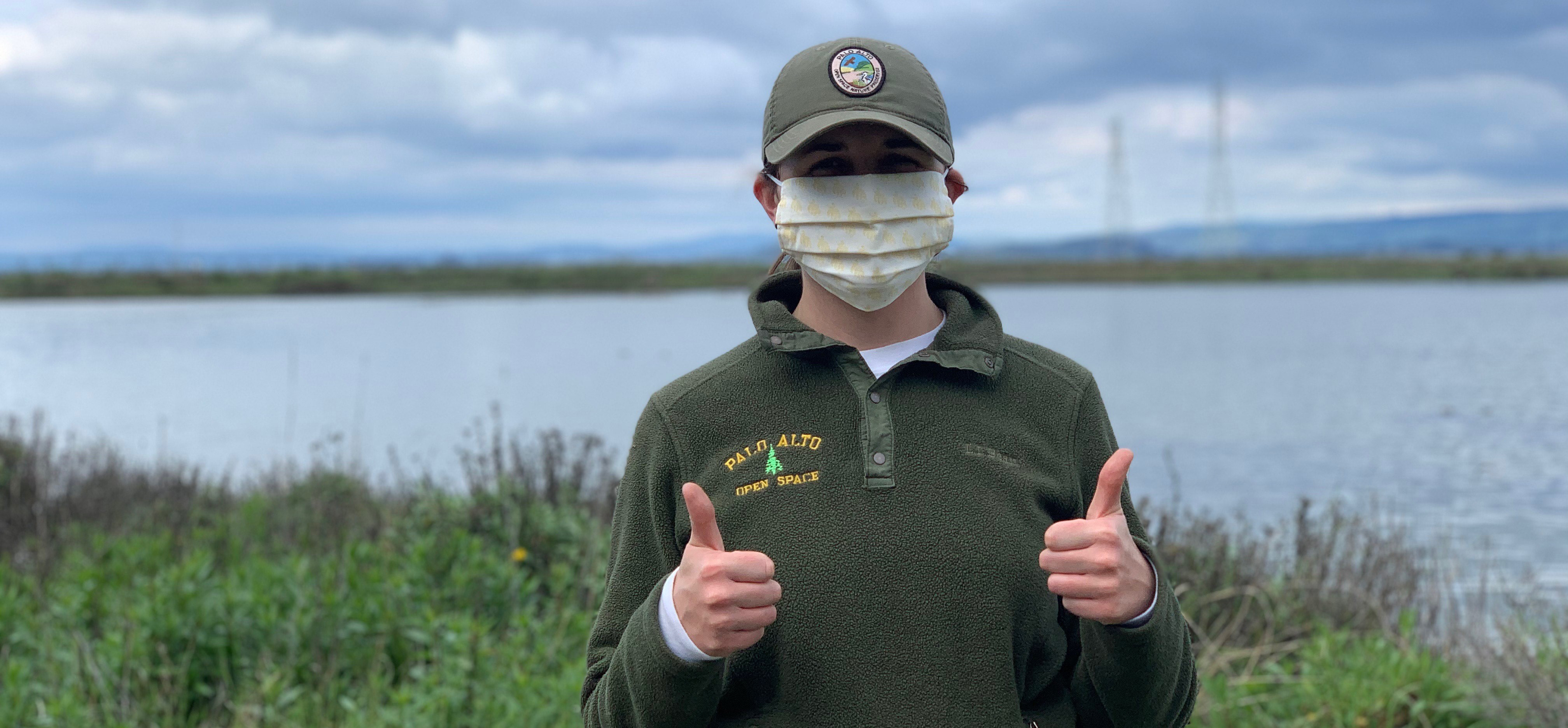 Baylands Ranger wearing a mask and showing support of safety measures with a thumbs up gesture