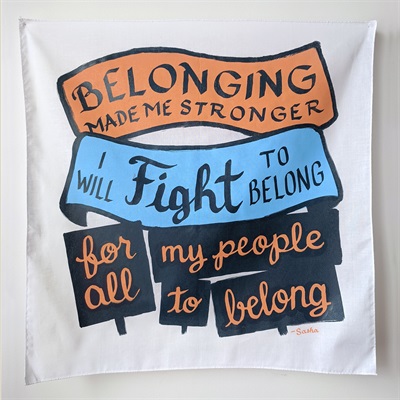 A bandanna on the wall with calligraphic text that reads: Belonging made me stronger, I will fight to belong, for all my people to belong