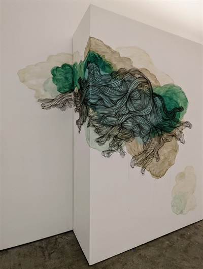 An abstract wall painting in shades of greens and beige and with a root-like drawing on the wall of the gallery