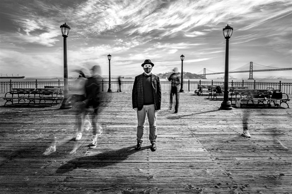 Black and white photo of man standing on promenade in SF