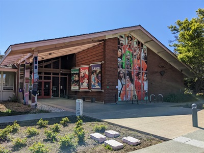 Photograph of Art Center entrance with mural and bright blue sky 
