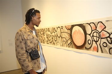 Image of a man in front of a large horizontal artwork