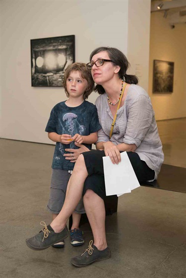 image of a seated woman looking at art next to a standing child