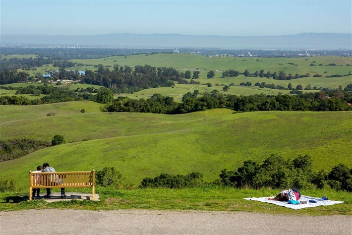 Foothills Nature Preserve, several people enjoying the view of the rolling green hills eastward toward Stanford, Downtown Palo Alto and the bay