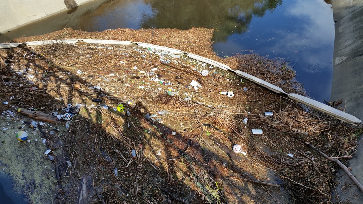 Trash boom deployed in Adobe Creek showing large amount of captured debris