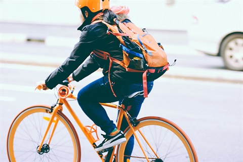 A person rides a bike with a helmet on the street