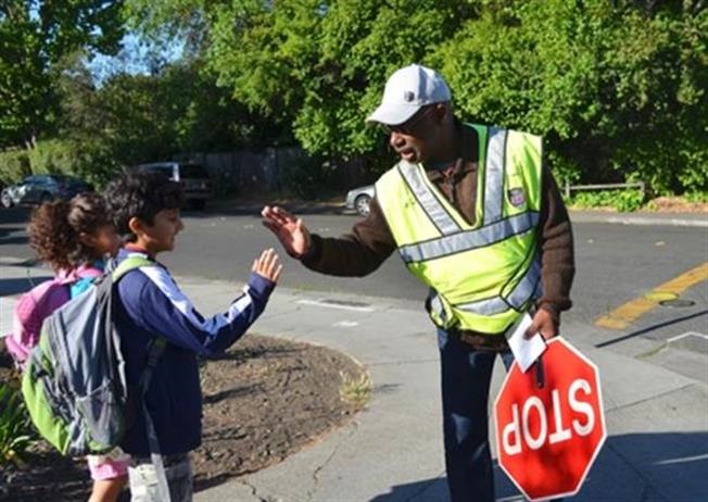 elementary students greeting a school crossing guard