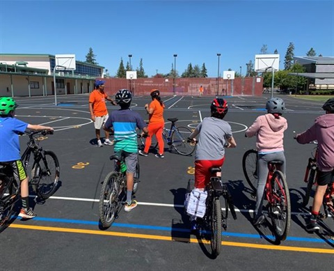 the image has palo alto children learning about bicycle safety through the bike rodeo program.