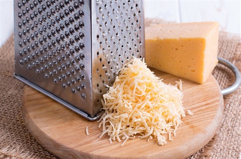 Cheese grater with block of cheese partially grated